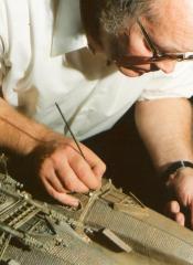 Frits Spies werkt aan kaars wasfiguur Bonifatiustoren liggend