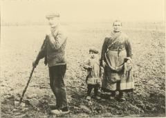 Portret ongeïdentificeerd landbouwersfamilie op veld