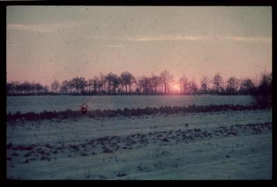 Besneeuwd, winters landschap met een ondergaande zon