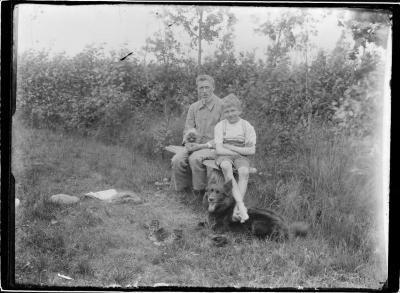 Clement Boone (1897-1986) en jongen met honden op bank.