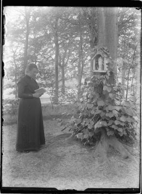 Vrouw bidt bij boomkapelletje