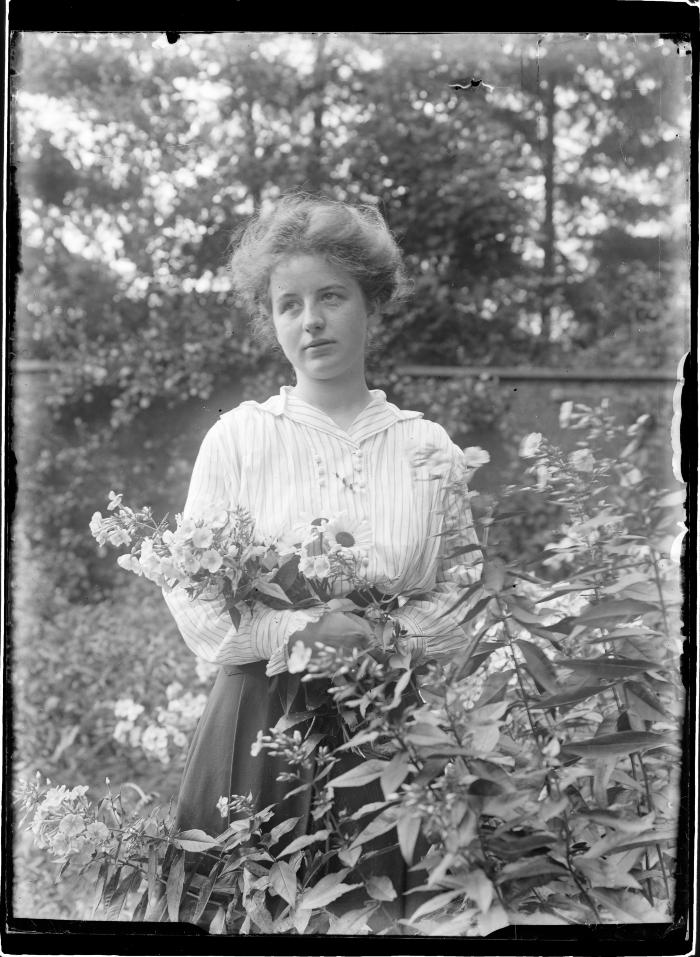  Elisabeth Versteylen "close up" met bloemen de Paai "bloemhofke".  Achter de muur.  Noordkant, een rij "epicea sparren".