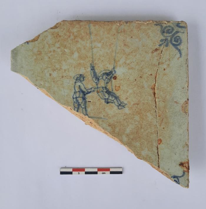 Tegel met twee schommelende figuren, ossekop als hoekmotief.