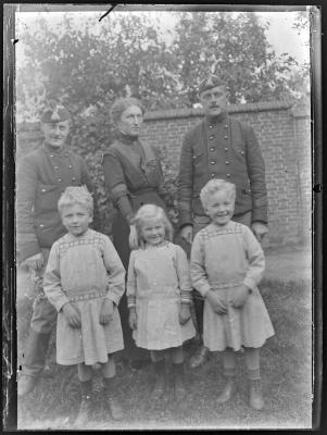 Familiefoto met een vrouw, twee militairen en drie kleine meisjes