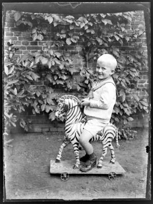 Jongen op houten paar met wieltjes