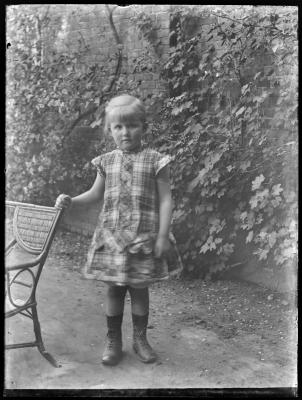 Meisje met stoel in tuin