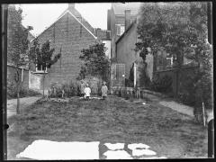 Drie kinderen in de tuin met wasgoed