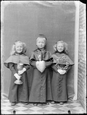 Drie kinderen (een jongen en twee meisjes) verkleed als geestelijken