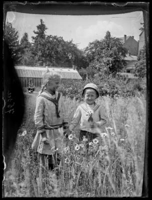 Twee kinderen in een tuin met bloemen