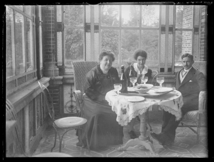 Een paar en een vrouw in een varanda.