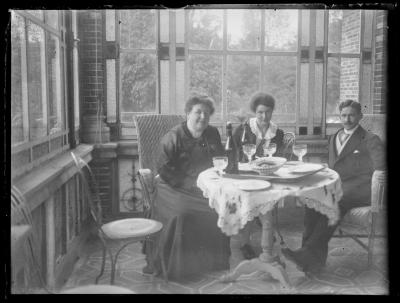 Een paar en een vrouw in een varanda.