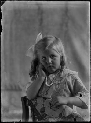 Meisje geknield op een stoel