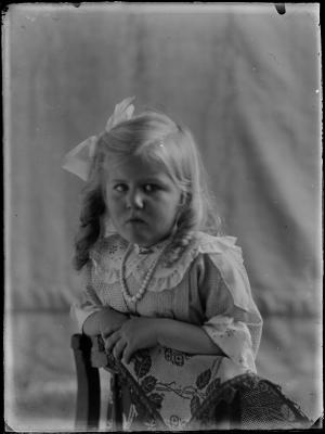 Meisje geknield op een stoel