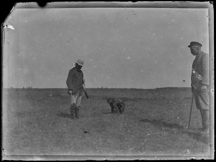 Jager, drijver en een hond in een veld