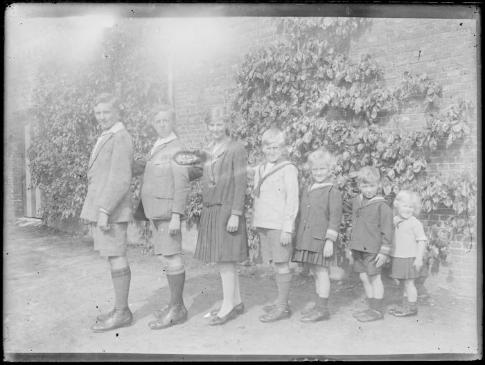 Zeven kinderen op een rij van groot naar klein