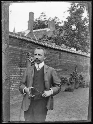 Portret van een man in een tuin.