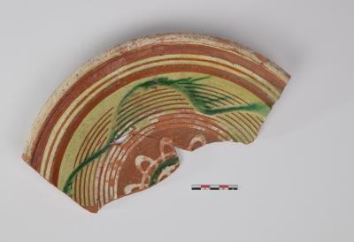 Bord in roodbakkend aardewerk met slibversiering 