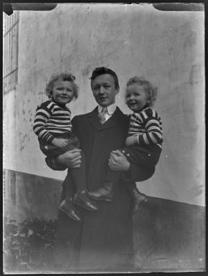 Man met twee peuters op de arm