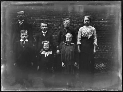 Familiefoto met drie volwassenen en vier kinderen
