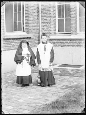 Meisje en jongen verkleed als non en misdienaar