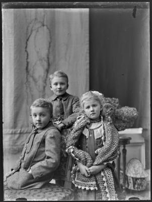 Meisje met grote sjaal en twee jongens meteen stoel